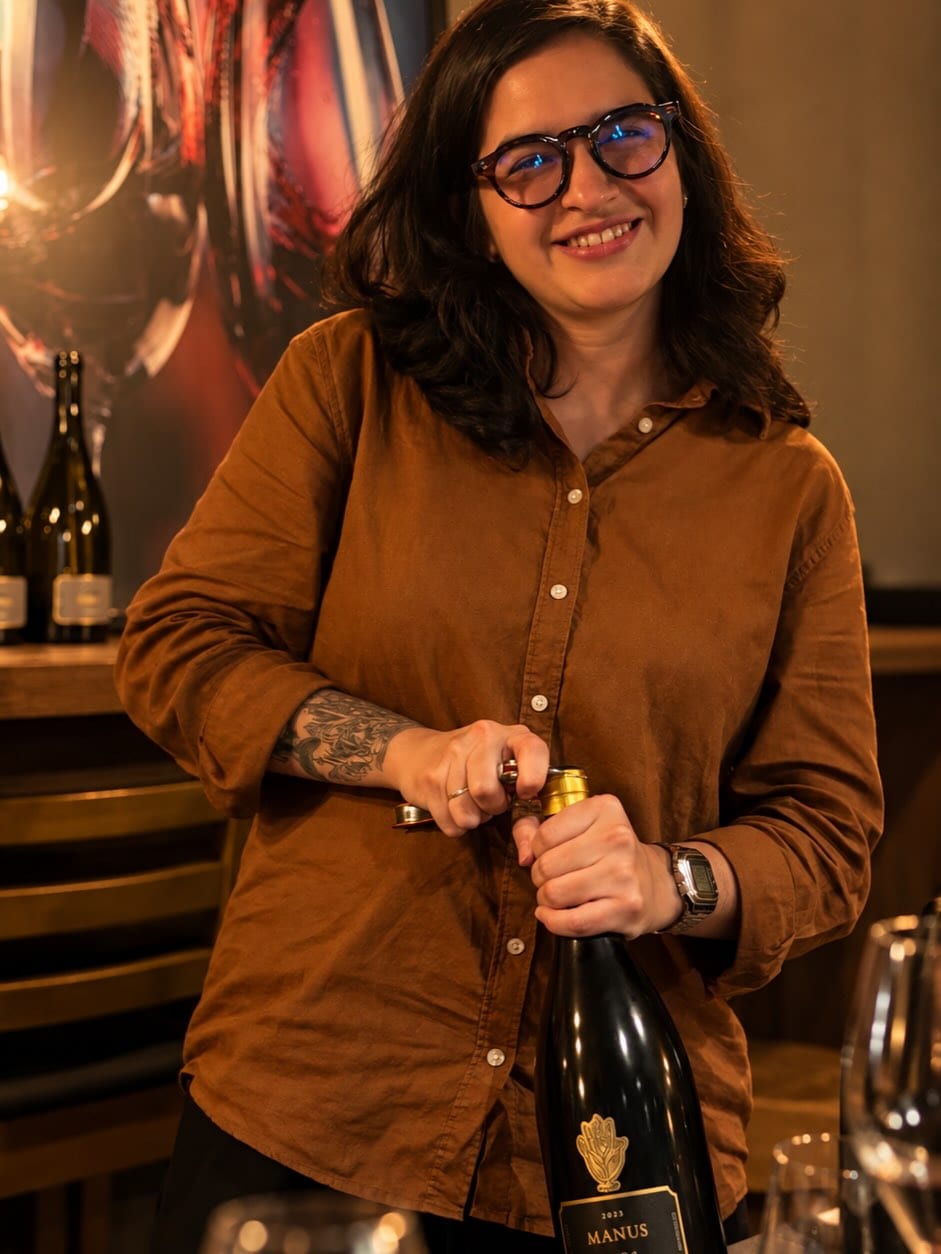Anfitriã da Wine Flow abrindo uma garrafa